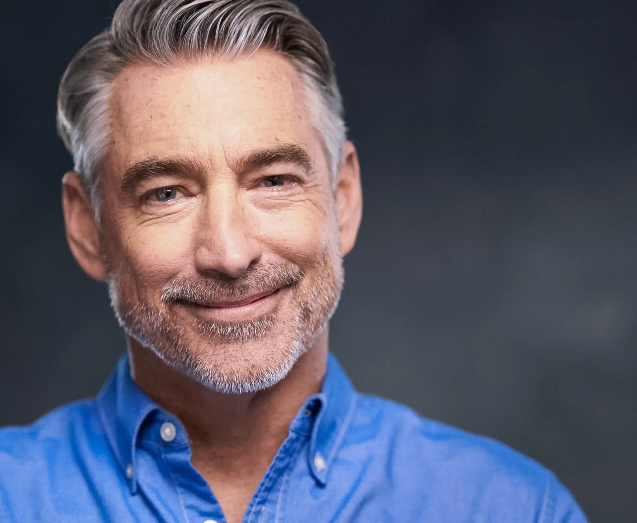 Business headshot of a middle aged man in a blue shirt